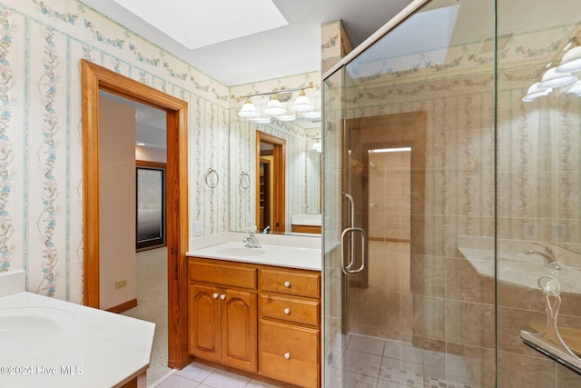 bathroom featuring vanity, a skylight, tile patterned floors, and an enclosed shower