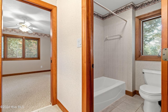 bathroom with ceiling fan, a healthy amount of sunlight, toilet, and tiled shower / bath combo