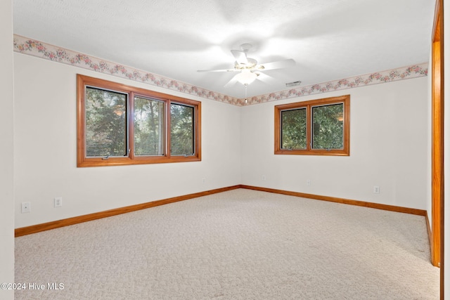 carpeted spare room featuring ceiling fan and a textured ceiling