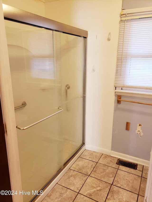 bathroom with tile patterned flooring and walk in shower