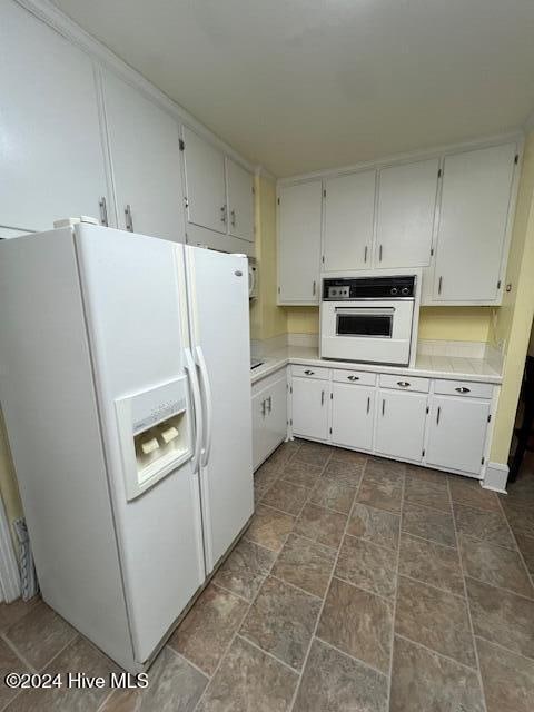 kitchen featuring white cabinets and white appliances