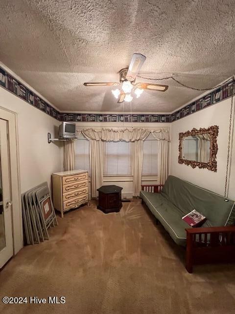 unfurnished room featuring carpet flooring, a textured ceiling, and ceiling fan