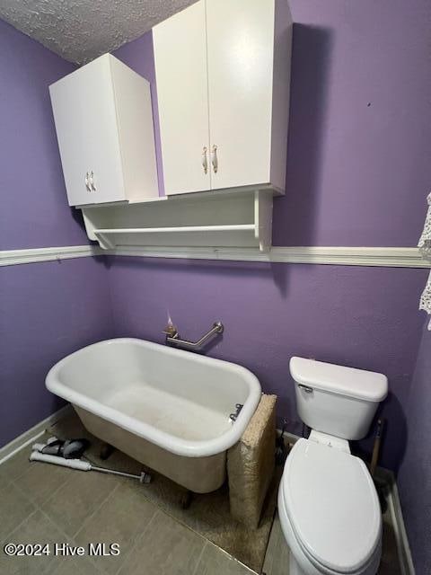 bathroom with sink, toilet, and a textured ceiling