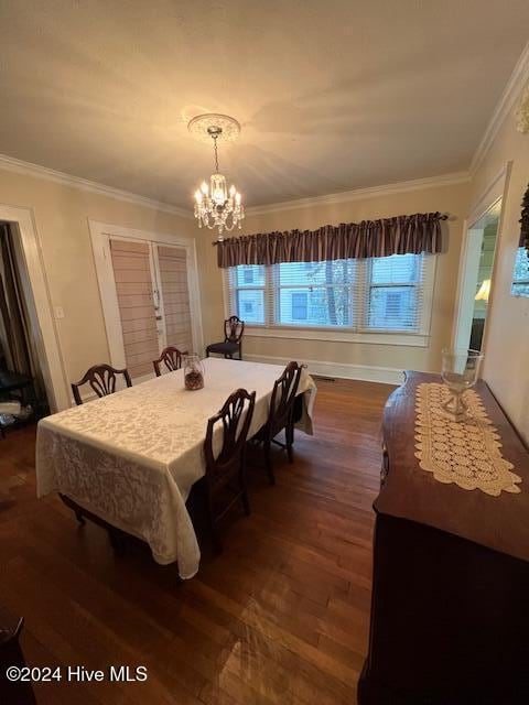 dining space with a chandelier, ornamental molding, and dark wood-type flooring