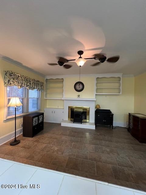 unfurnished living room featuring ceiling fan and crown molding