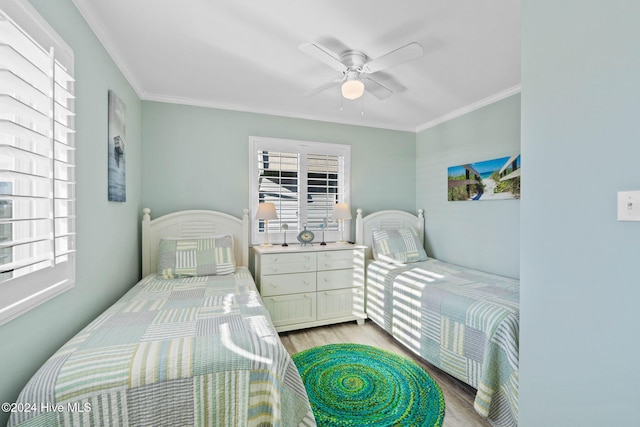 bedroom featuring ceiling fan, ornamental molding, and light hardwood / wood-style flooring