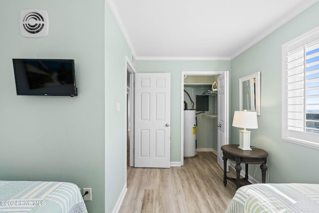 bedroom with water heater, ornamental molding, a walk in closet, light wood-type flooring, and a closet