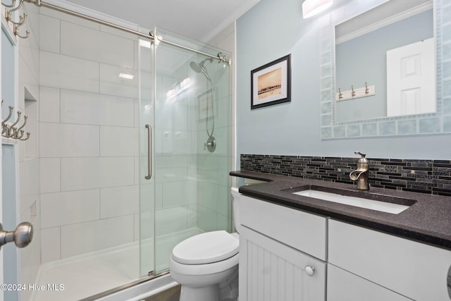 bathroom featuring crown molding, vanity, an enclosed shower, decorative backsplash, and toilet