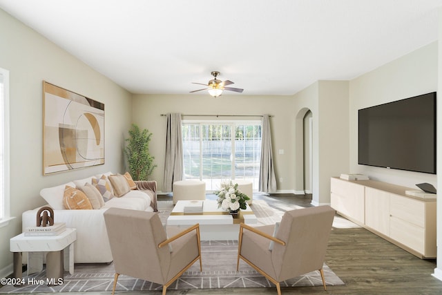 living room featuring ceiling fan and dark hardwood / wood-style flooring