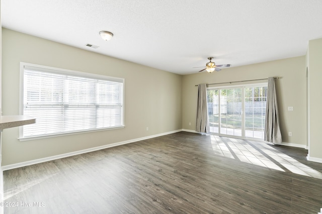 spare room featuring ceiling fan, dark wood-type flooring, and a textured ceiling