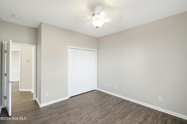 unfurnished bedroom featuring ceiling fan, dark hardwood / wood-style flooring, and a closet