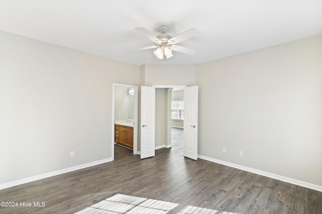 unfurnished bedroom with ensuite bathroom, ceiling fan, and dark hardwood / wood-style flooring