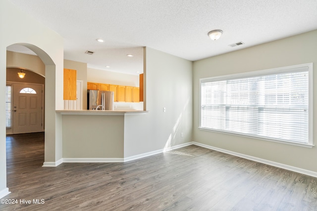 interior space featuring a textured ceiling and dark wood-type flooring