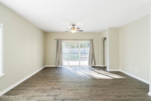 empty room with ceiling fan and dark wood-type flooring