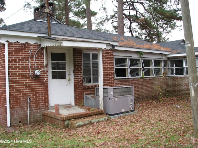 rear view of property with cooling unit