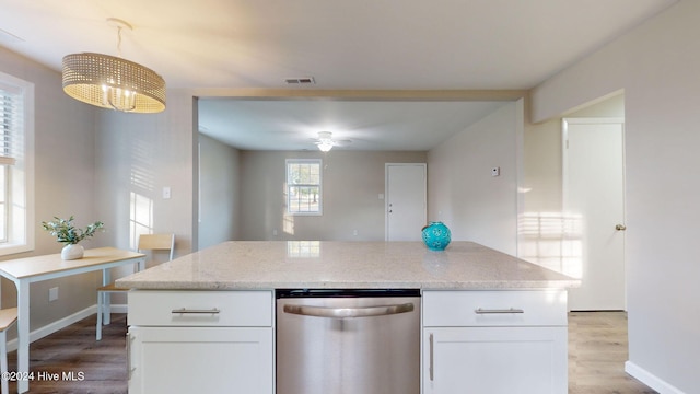 kitchen featuring stainless steel dishwasher, light stone countertops, white cabinetry, and light hardwood / wood-style flooring