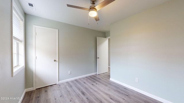 unfurnished bedroom with light wood-type flooring, multiple windows, and ceiling fan