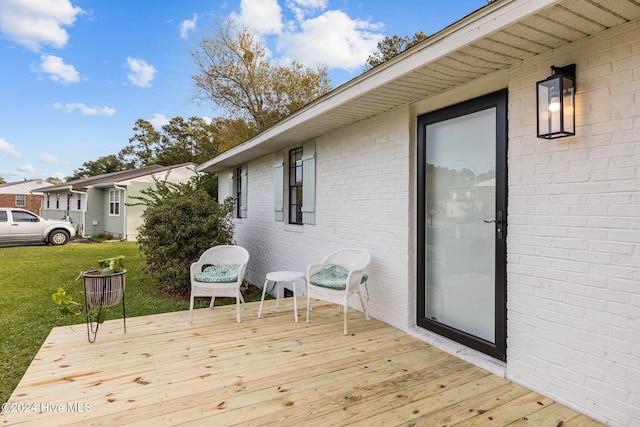 wooden deck featuring a lawn