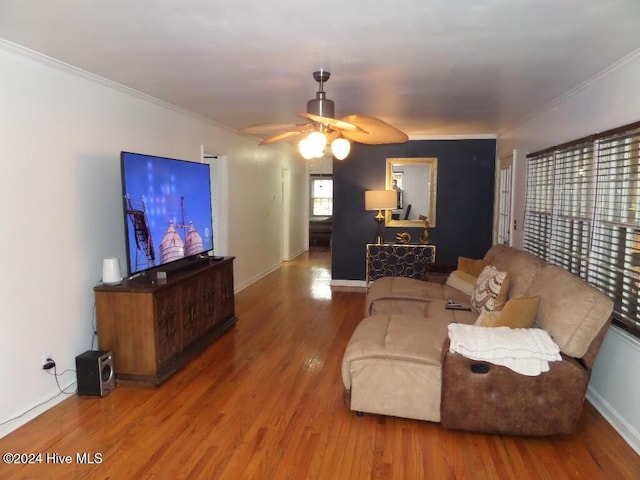 living room featuring hardwood / wood-style flooring, ornamental molding, and ceiling fan