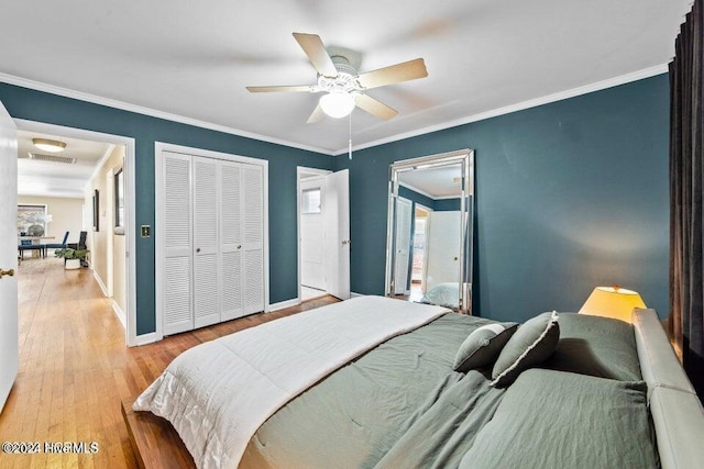 bedroom featuring crown molding, ceiling fan, a closet, and light wood-type flooring