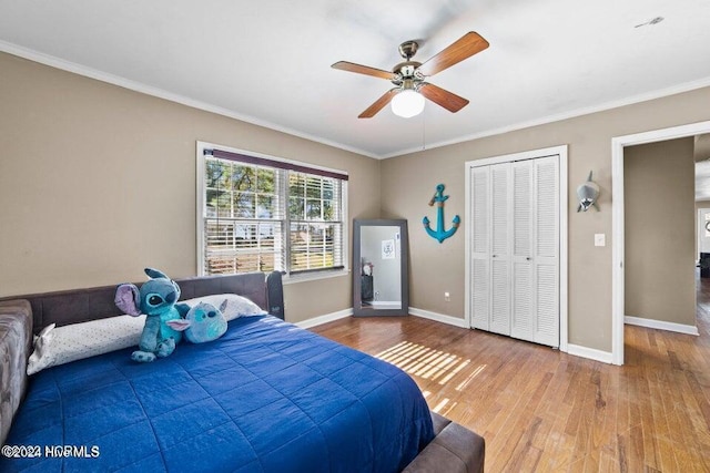 bedroom featuring hardwood / wood-style flooring, ornamental molding, ceiling fan, and a closet