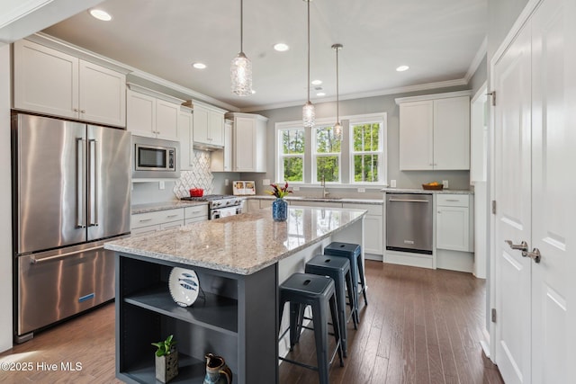 kitchen featuring high end appliances, ornamental molding, open shelves, white cabinets, and a sink