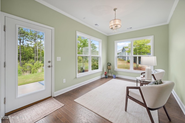 living area featuring baseboards, a chandelier, crown molding, and dark wood-type flooring