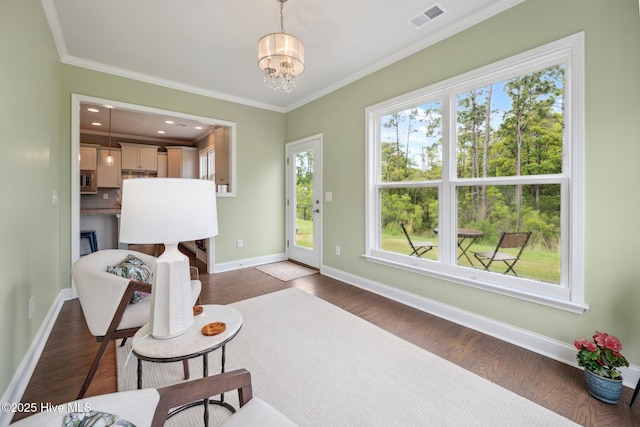 foyer featuring a chandelier, wood finished floors, crown molding, and baseboards