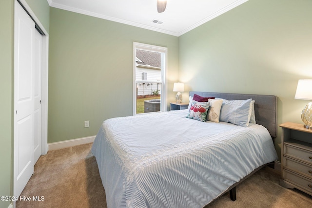 carpeted bedroom with ornamental molding, a closet, baseboards, and ceiling fan