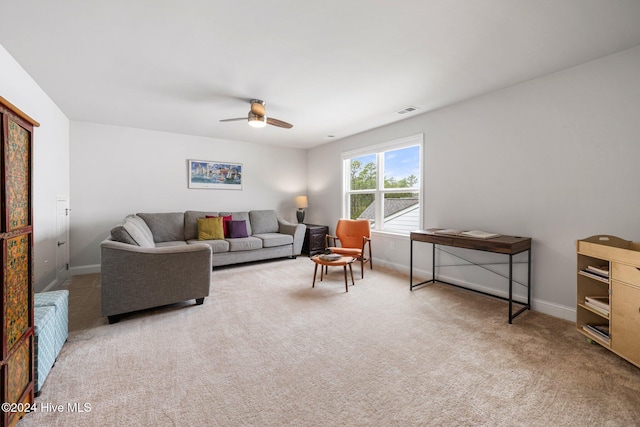 carpeted living area featuring a ceiling fan and baseboards