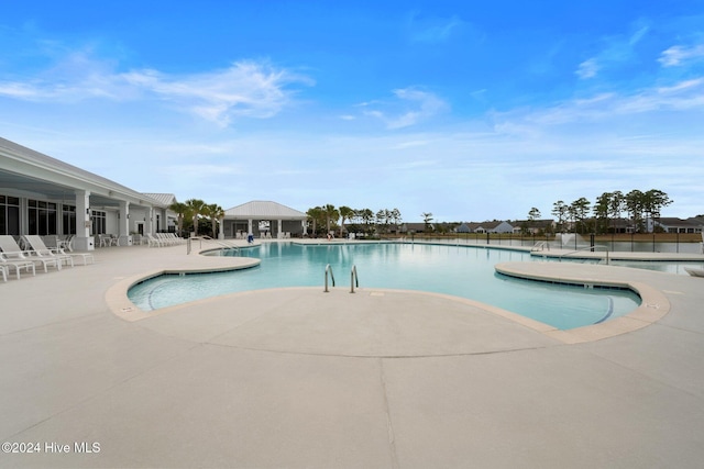community pool with a patio and fence