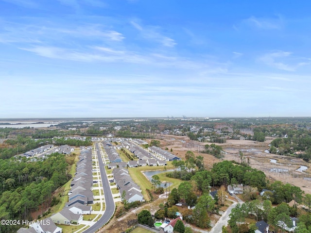 aerial view of property and surrounding area featuring nearby suburban area and a nearby body of water
