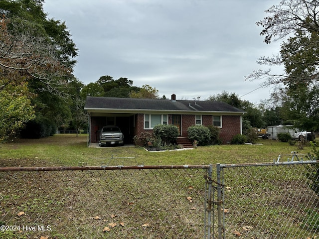 ranch-style home featuring an attached carport, brick siding, a front lawn, and a fenced backyard