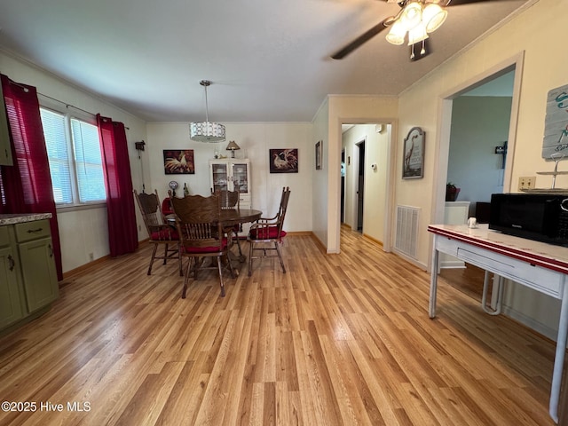 dining area featuring crown molding, visible vents, light wood-style flooring, and ceiling fan