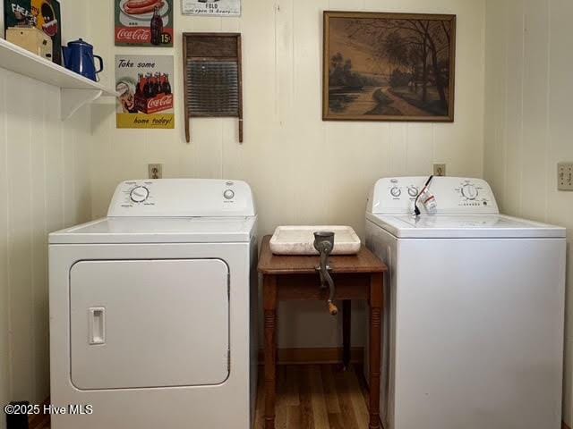 laundry room with independent washer and dryer, wood finished floors, and laundry area