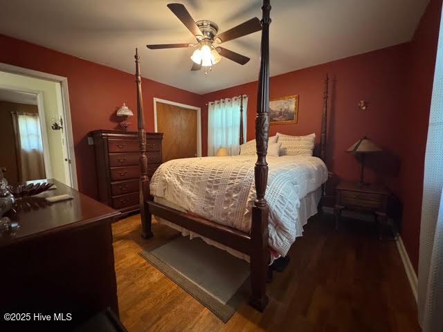 bedroom featuring ceiling fan, baseboards, and wood finished floors