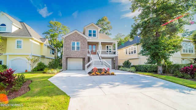 view of front of home featuring a front lawn, covered porch, and a garage