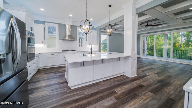 kitchen with a healthy amount of sunlight, white cabinetry, wall chimney range hood, and stainless steel appliances