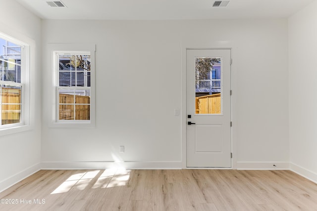 interior space with light wood-style floors, visible vents, and baseboards