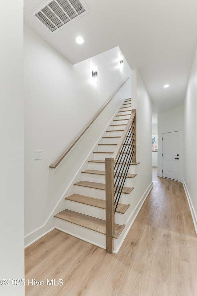 staircase with baseboards, visible vents, wood finished floors, and recessed lighting