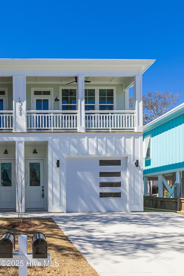 view of front of property featuring a garage, concrete driveway, and a balcony