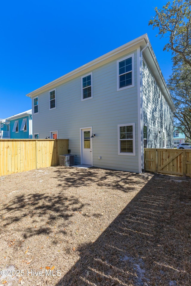 back of property with a gate and fence