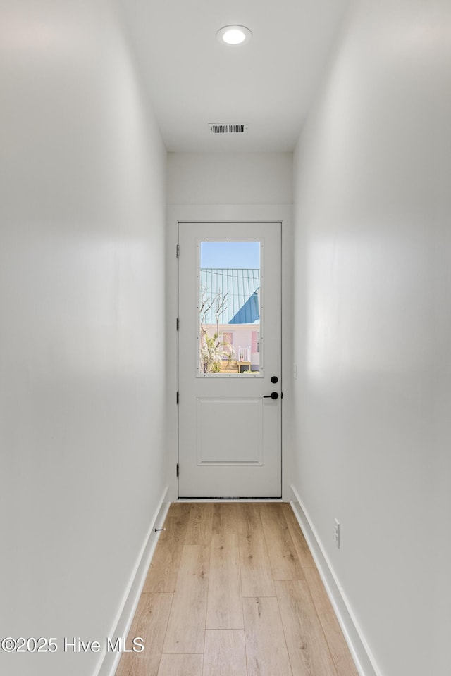 entryway with light wood-type flooring, visible vents, and baseboards