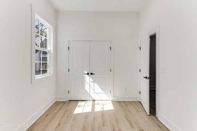 interior space featuring light wood-type flooring and baseboards