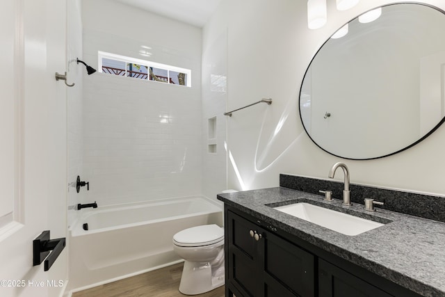 bathroom featuring toilet, washtub / shower combination, wood finished floors, and vanity