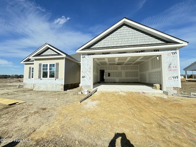 view of front of property with a garage, dirt driveway, and board and batten siding