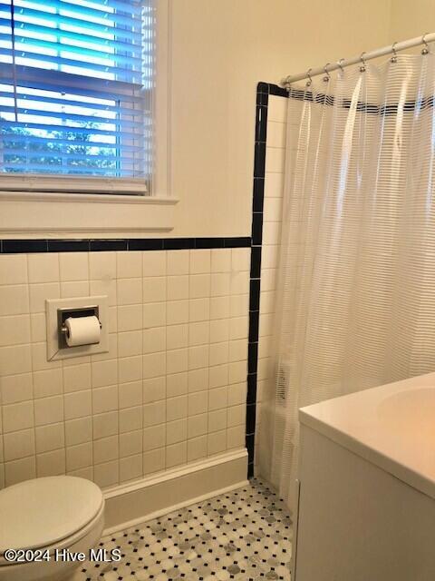 bathroom with tile patterned floors, toilet, and walk in shower