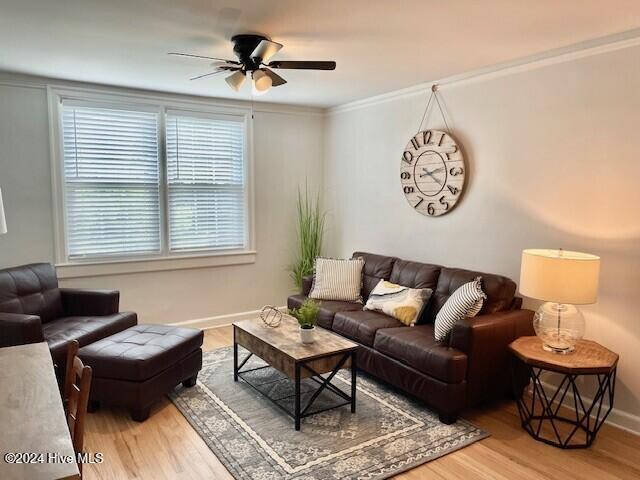 living room with ceiling fan, wood-type flooring, and crown molding