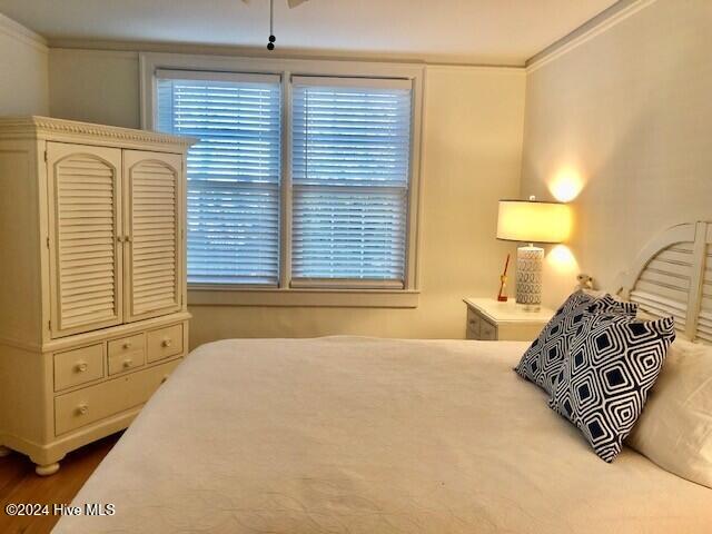 bedroom featuring hardwood / wood-style flooring and crown molding