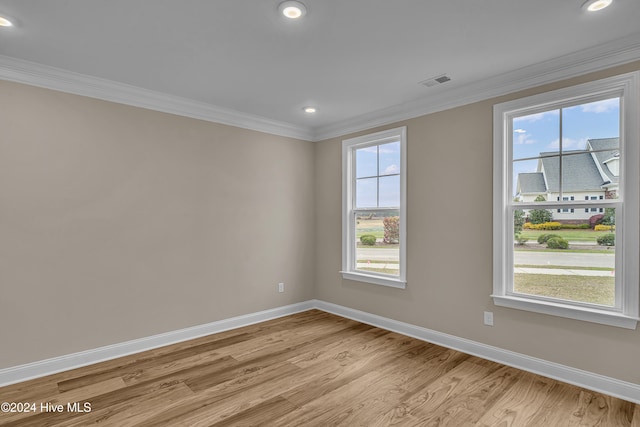 empty room featuring light hardwood / wood-style floors and crown molding